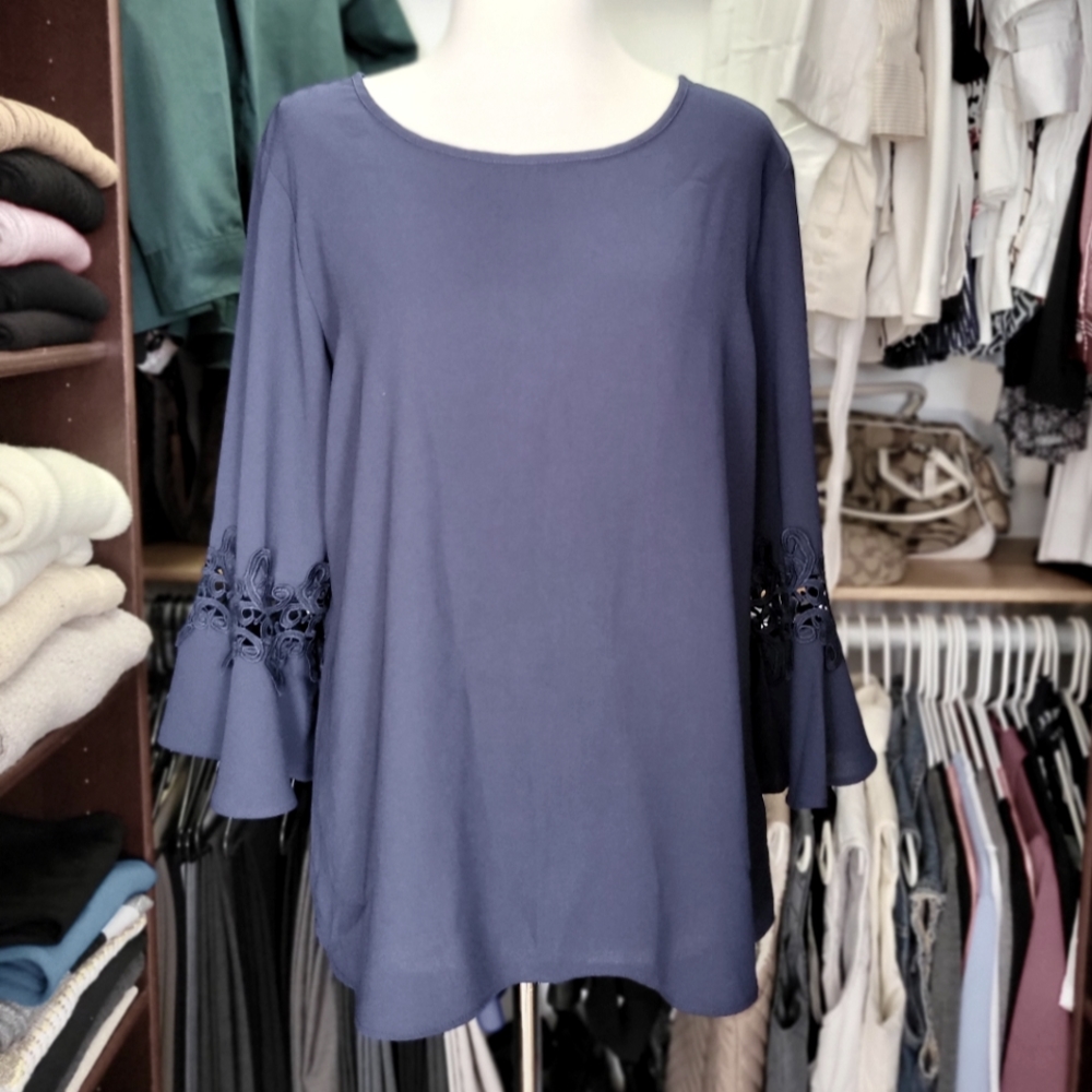 Lifestyle attitude, large, navy blue blouse with see-through lace sleeves.